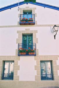 a building with three windows and flowers on it at El Encanto in Miraflores de la Sierra +2 photos