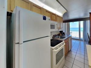 un réfrigérateur blanc dans une cuisine avec vue sur l'océan dans l'établissement Harbour Beach Resort 303, à Seabreeze