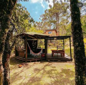 a cabin with a hammock and a table on a porch at Cabin Refuge in Urubici