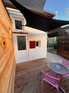 - une terrasse avec 2 chaises, une table et une porte dans l'établissement A deux pas de la gare, La Maison Rouge, à Albertville