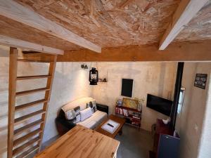 Cette chambre comprend une mezzanine, un canapé et une table. dans l'établissement A deux pas de la gare, La Maison Rouge, à Albertville