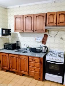 a kitchen with wooden cabinets and a sink and a stove at Paraíso Costero San Bernardo in San Bernardo