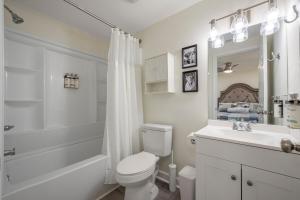 a white bathroom with a toilet and a sink at The Pine House in Davidson +34 photos