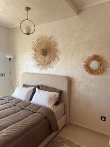 - une chambre avec un lit et deux miroirs sur le mur dans l'établissement T2 moderne avec vue mer - Résidence avec piscine, à Hajreien