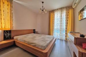 1 dormitorio con 1 cama grande y cortinas amarillas en Apartments Nessebar, en Nesebar 5 fotos más