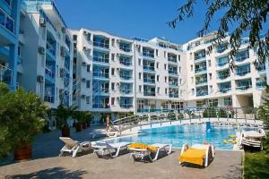 Un gran edificio de apartamentos blanco con piscina. en Apartments Nessebar, en Nesebar