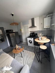 - une cuisine avec un canapé et une table dans une chambre dans l'établissement La Chambre de Sophie - Studio et garage au calme, proche centre ville, à Lons-le-Saunier 3 autres photos