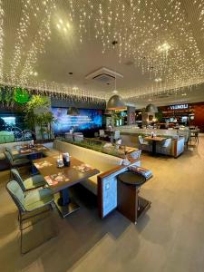 ein Restaurant mit Tischen und Stühlen und eine Bar in der Unterkunft Holanda's Prime in Tambaú