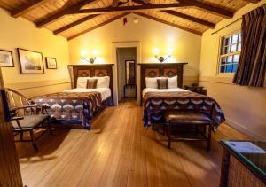 a bedroom with two beds and chairs in a room at Zion Lodge - Inside the Park in Springdale