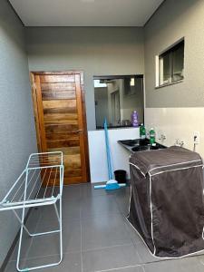 une cuisine avec une table, un évier et un comptoir dans l'établissement Casa garagem camionete, 2 quartos, espaço para 6 pessoas, 5min Centro - Casa 5, à Sinop