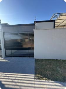 - un bâtiment avec une clôture et des escaliers devant dans l'établissement Casa garagem camionete, 2 quartos, espaço para 6 pessoas, 5min Centro - Casa 5, à Sinop