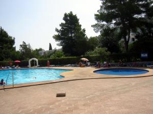 a large swimming pool with people sitting around it at Siesta Mar Apartamentos Ibiza in Santa Eularia des Riu +18 photos