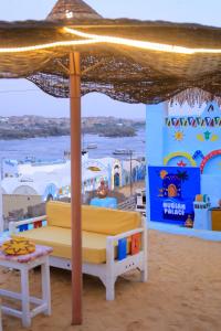 a bed under an umbrella on the beach at Nubian Palace Eco Lodge in Aswan
