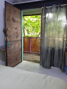 une porte ouverte menant à une chambre avec fenêtre dans l'établissement Colors Hostal, à Boquete