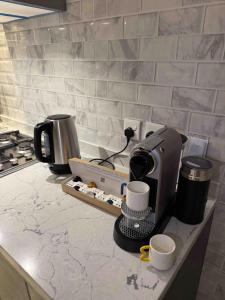 a kitchen counter with a coffee maker and two cups at دهم الرمك in Khamis Mushayt