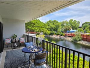 un balcone con tavolo, sedie e un fiume di Parkshore resort apartment a Naples