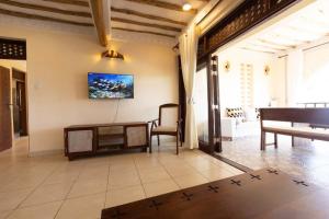 a living room with a table and a tv on the wall at Munje Luxury Beach Villas in Msambweni