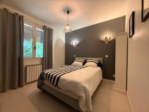 a bedroom with a bed with a black and white blanket at Les coquelicots in Villeneuve-sur-Lot