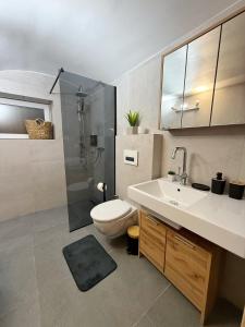 a bathroom with a toilet and a sink and a shower at URBAN BASE CELJE Apartment with FREE Parking & Terrace in Celje