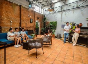 a group of people sitting in a room with a man speaking at Viajero San José Hostel in San José