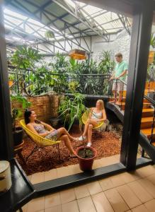 two women sitting in chairs in a greenhouse at Viajero San José Hostel in San José
