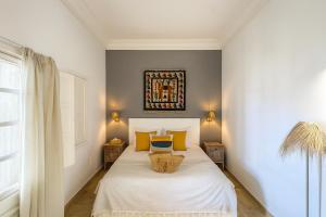 a bedroom with a white bed with yellow pillows at Dar Benti in Monastir +64 photos