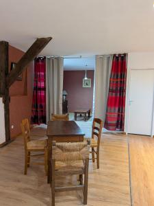 Un comedor con mesa y sillas de madera. en Avenois 2, en Fourmies