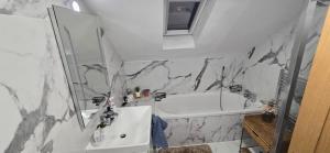 une salle de bain avec une baignoire blanche, un lavabo et un miroir dans l'établissement The Shinki House, à Nottingham 19 autres photos