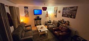 un salon avec deux canapés et une télévision dans l'établissement The Shinki House, à Nottingham