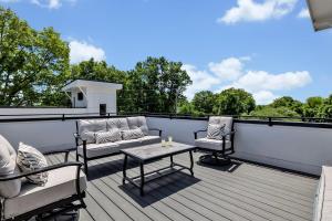 a patio with two chairs and a table on a deck at Double Treble - 2 Townhomes - Private Rooftops in Nashville