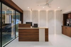 an office with a reception desk with a ceiling fan at Hotel Saffron Groves in Hyderabad