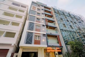 a tall building with a sign in front of it at Hotel Saffron Groves in Hyderabad