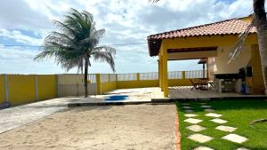 une maison avec un palmier et un patio dans l'établissement São Luiz Experiência Única: Casa na Areia da Praia do Meio, à São José de Ribamar