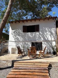 Un edificio blanco con dos sillas y una chimenea. en Hospedaje Tola, en Caacupé