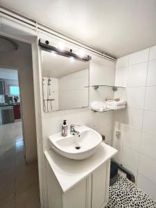 Un baño blanco con lavabo y espejo. en Quiet in Bry, close to Paris & Disney, large room, en Bry-sur-Marne
