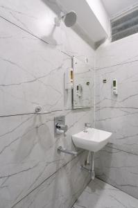 a white bathroom with a sink and a mirror at Hotel Saffron Groves in Hyderabad +54 photos