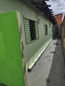a green building with two windows and a alley at Casa Lins para 15 pessoas in Lins