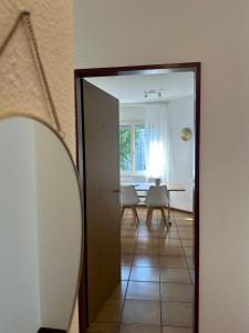 a room with a mirror and a table with chairs at QuietApartment in Bellinzona +7 photos