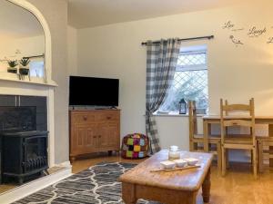 a living room with a fireplace and a table at Little Velvet Hall Character Cottage in Velvethall Station
