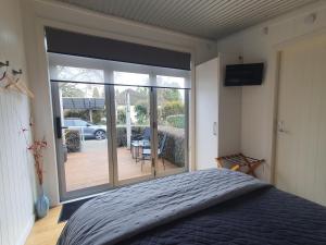 a bedroom with a bed and a sliding glass door at The Cube in Martinborough 