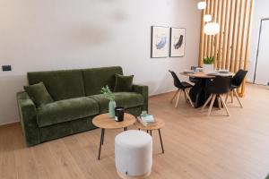 a living room with a green couch and tables at Casa Teresinella Pompei in Pompei