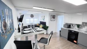 a kitchen and living room with a table and chairs at 1 bedroom guesthouse including parking on premises in Braintree