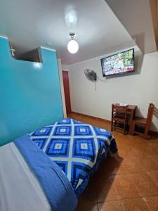 a bedroom with a bed and a tv on the wall at Hostal Leo in Lima