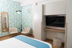 een slaapkamer met een bed en een televisie en stoelen bij Casa Teresinella Pompei in Pompei