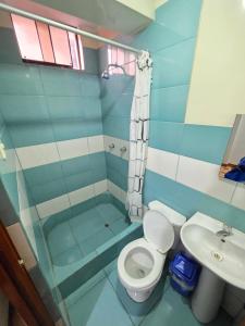 a blue bathroom with a toilet and a sink at Hostal Leo in Lima +4 photos