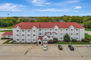 a large white building with a red roof at Ramada Limited Bloomington IL I-74/I-55 in Bloomington
