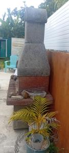 a stone fireplace with potted plants on a patio at PASSION de PARADIS in Rivière-Pilote +1 photo