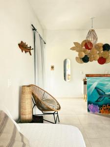 a bedroom with a chair and a painting on the wall at Pousada Nascente do Sol in Ilha de Boipeba