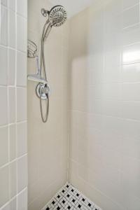 une douche avec pommeau de douche dans une salle de bain dans l'établissement Holiday stays now available! Easy beach access!, à New Smyrna Beach