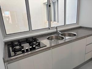 a kitchen counter with a sink and a stove at GP Apartamentos in São Filipe +10 photos